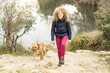 Curly and blonde hair, mountaineer woman and her dog walking through the mountains.