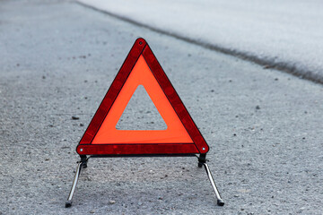 Emergency vehicle stop sign, standing on a paved road.