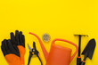 Orange gardening tools on color background, top view