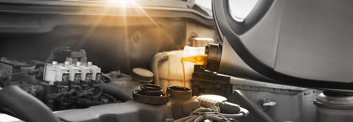 Pouring motor oil into car engine, color accent effect. Banner design