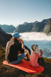 © EVERST - Family camping in mountains travel vacations father and daughter eating snacks outdoor dad with child hiking together active adventure tour in Norway picnic above clouds