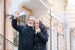 © luengo_ua - age, tourism, travel, technology and people concept - senior caucasian couple with camera phone taking selfie on street