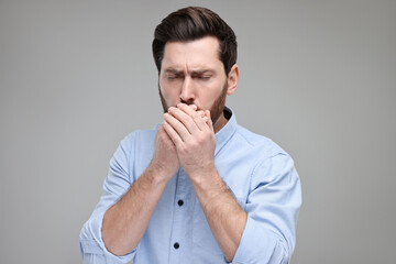 Poster - Sick man coughing on light grey background. Cold symptoms