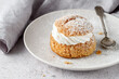 © BarTa - Cream puffs, semla, pastry from choux covered sugar powder on white plate over stone table background. Sweet dessert with chantilly cream