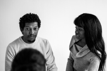 African american couple sitting at psychologist's office for a couples therapy - Couple relationship concept in trouble and crisis - Focus on man's face -  Black and white editing