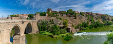 Panorama Of The Old Historical City Of Toledo With The Bridge Puente De San Martín On The Left And The River Rio Tajo In Front. Toledo, Spain