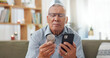 © Wesley/peopleimages.com - Phone, pills and senior man at home, reading label, medicine information and confused for telehealth service or FAQ. Elderly person on sofa with pharmaceutical bottle or tablet with mobile questions