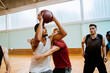 © Marko Geber - Basketball players playing basketball in an indoor basketball gym