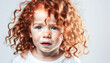 Portrait of a beautiful unhappy kid. Curly red hair and freckles. Scared sad little child crying,