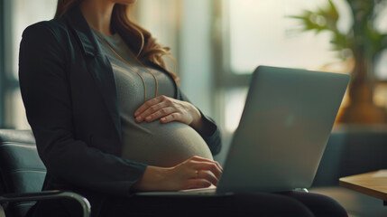 pregnant woman in a professional setting, working on a laptop.