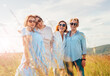 © Soloviova Liudmyla - Portrait of four cheerful smiling and laughing women embracing during outdoor walking by high green grass hill. They looking at the camera. Woman friendship, relations, and happiness concept image.