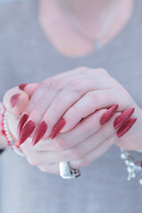Wall Mural - Female hands with long nails and dark red nail polish