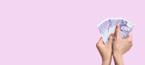 Fototapeta Mapy - Female hands holding money on lilac background with space for text