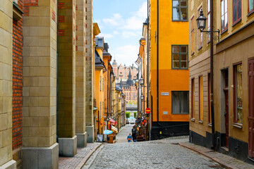 View from the Tyska Brinken street in the medieval old town of Gamla Stan island, looking across the water to the Mariahissen elevator building, in Stockholm, Sweden.