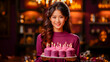 Portrait of beautiful young woman with birthday cake in her hands.