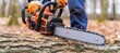 Construction worker cutting trees with gasoline chainsaw, close up shot with copy space
