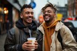 © LifeMedia - Two joyful friends enjoying a light moment together on a city street with coffee