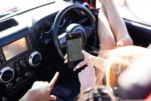 A person is using a smartphone for navigation in a car on a road trip