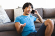 © Wavebreak Media - Teenage Asian boy chats on the phone at home, relaxed on a couch
