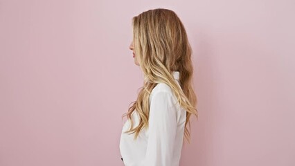 Wall Mural - Confident young blonde woman in a relaxed natural pose, smiling cheekily while looking off to the side - isolated over pink backdrop