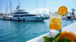 Background strolling along a bustling harbor admiring the elegant yachts docked while sipping on a refreshing glass of lemonade.