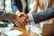 Detailed close-up of a handshake between two professionals in an office setting with a blurred meeting background