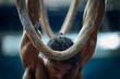 An athlete grips onto worn gymnastic rings, showcasing physical strength and determination