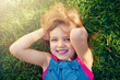 © Katie/peopleimages.com - Portrait, smile and top view of child on grass at park to relax, cute and lying outdoor to travel in nature. Face, above and happy girl on lawn in garden for holiday, summer and vacation in Australia