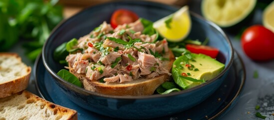 Poster - A dish of tuna salad with avocado and tomatoes, topped with lime or lemon, served on a plate as part of a delicious meal