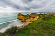 Rugged shoreline with rocky formations, a sandy beach, and cloudy sky, Algarve, Portugal