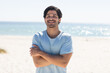 Young biracial man smiles at the beach