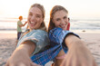 Two young Caucasian women share a joyful moment on the beach