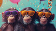 three happy chimpanzee monkeys with party hats and glasses