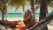 An older woman, a grandma, lies in the hammock between palm trees on a tropical sandy beach, retirement age emigrated or summer vacation long-distance trip, fictional location