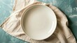 © Jennifer - Top view on colored background empty round white plate on tablecloth for food. Empty dish on napkin with space for your design