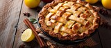 Fototapeta  - A crostata made with Meyer lemon filling, topped with cinnamon sticks, sits on a wooden table surrounded by fresh lemons and citrus ingredients