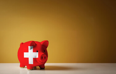 Wall Mural - Piggy bank with painting of Switzerland flag. The problem is in the economy. Economic crisis. Saving money concept.