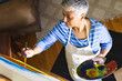 © Wavebreak Media - A mature biracial woman paints on canvas at home