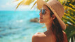 Woman in a straw hat and sunglasses enjoying a sunny tropical beach backdrop.
