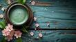 Cup of matcha latte green tea and spring flowers on rustic wooden background