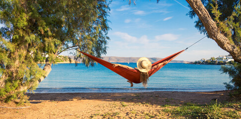 Wall Mural - Relaxing woman lying in hammock on beautiful tropical beach