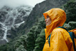 Hiker woman hiking in a yellow raincoat in rain. Healthy active lifestyle.
