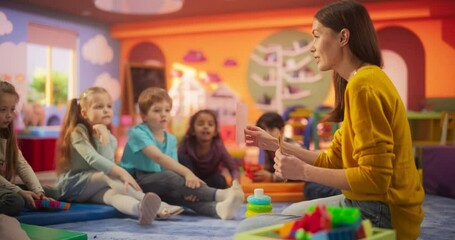 Wall Mural - Female Preschool Teacher Playing and Creatively Studying with Multiethnic Kids in Kindergarten. Small Adorable Children Getting Basic Reading and Writing Skills, Learning Alphabet in a Fun Way