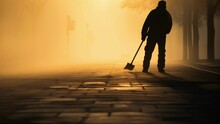 Through The Fog Of The Morning Light A Paving Worker Pauses For A Moment To Scan The Area They Are About To Work The Sun Illuminating The Blackened Pavement Under Their Feet.