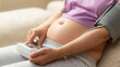 © Pixel_Studio_8 - Measure blood pressure pregnant. Woman measuring her blood pressure during pregnancy in the living room. Concept of high blood pressure in pregnancy. Selective focus and blur background for copy