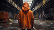 © AdamDiezel - a person in an orange jacket stained with black fuel oil dripping from it, in a dirty abandoned industrial area