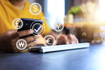 Currency exchange and mobile banking transaction concept with man in yellow t shirt using smart phone to transfer money by application for international transaction