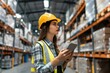 © sambath - A female employee or supervisor checks the stock inventory on a digital tablet as part of a smart warehouse management system
