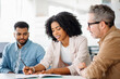 © Vadim Pastuh - Engagement and teamwork in an office where a woman in a white blazer engages in a lively discussion with her colleagues, analyzing documents or making strategic planning together