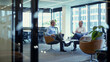 © Studio Zenith - deux hommes d'affaires discutant dans un bureau vitré donnant sur la ville